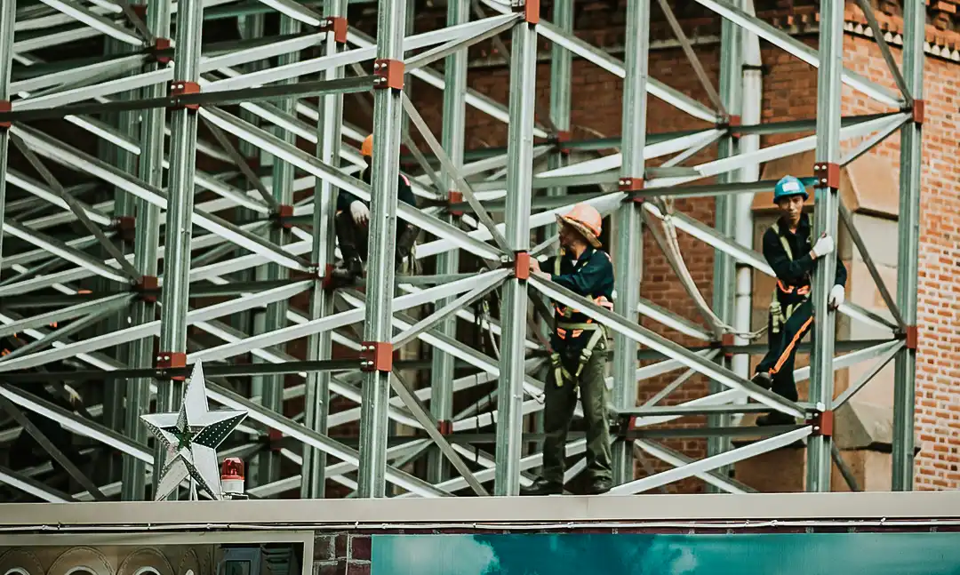 کارگری در حال کار بر روی اسکلت فلزی ساختمان